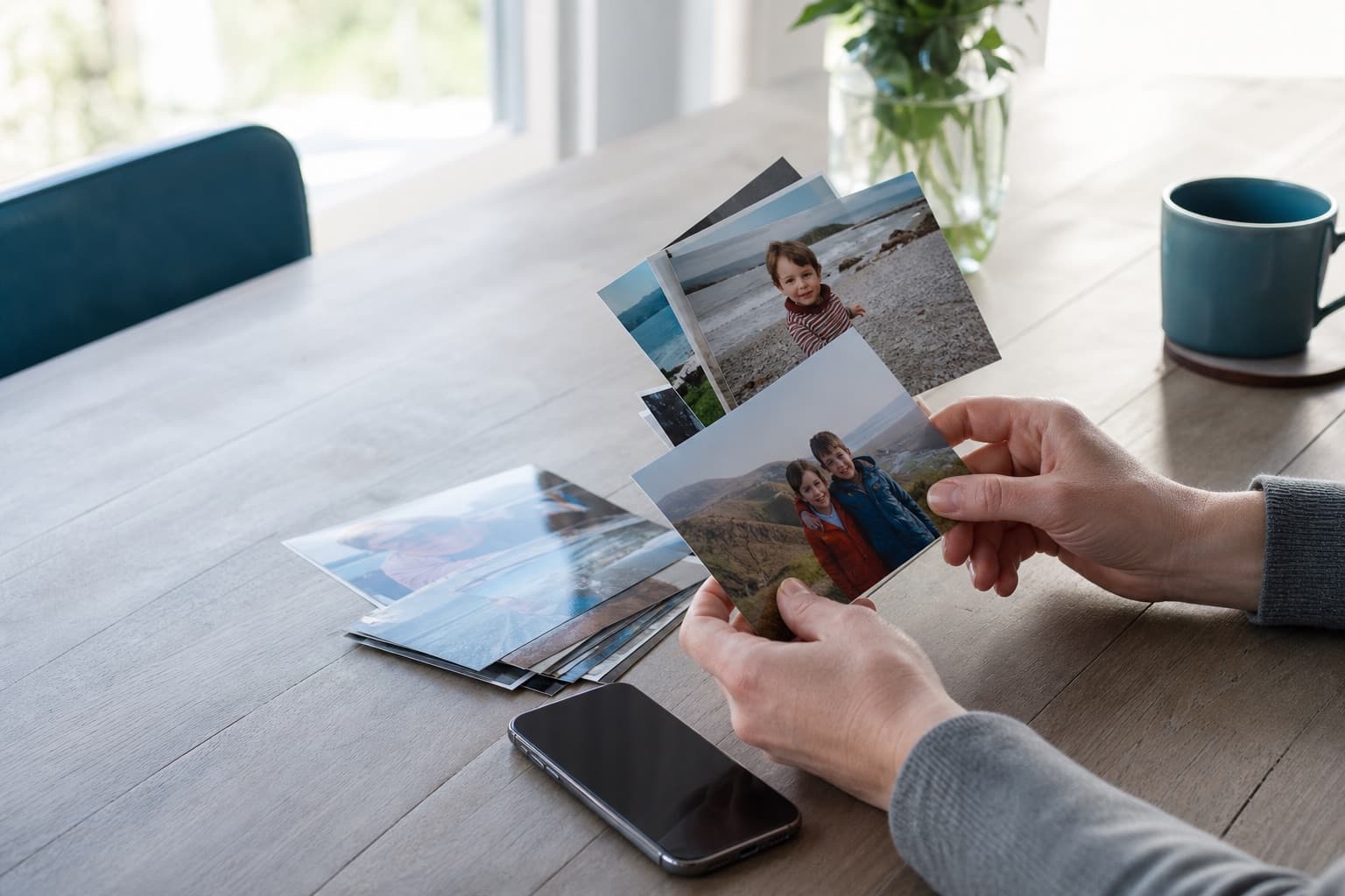 A customer sorting family photo prints beside their iPhone