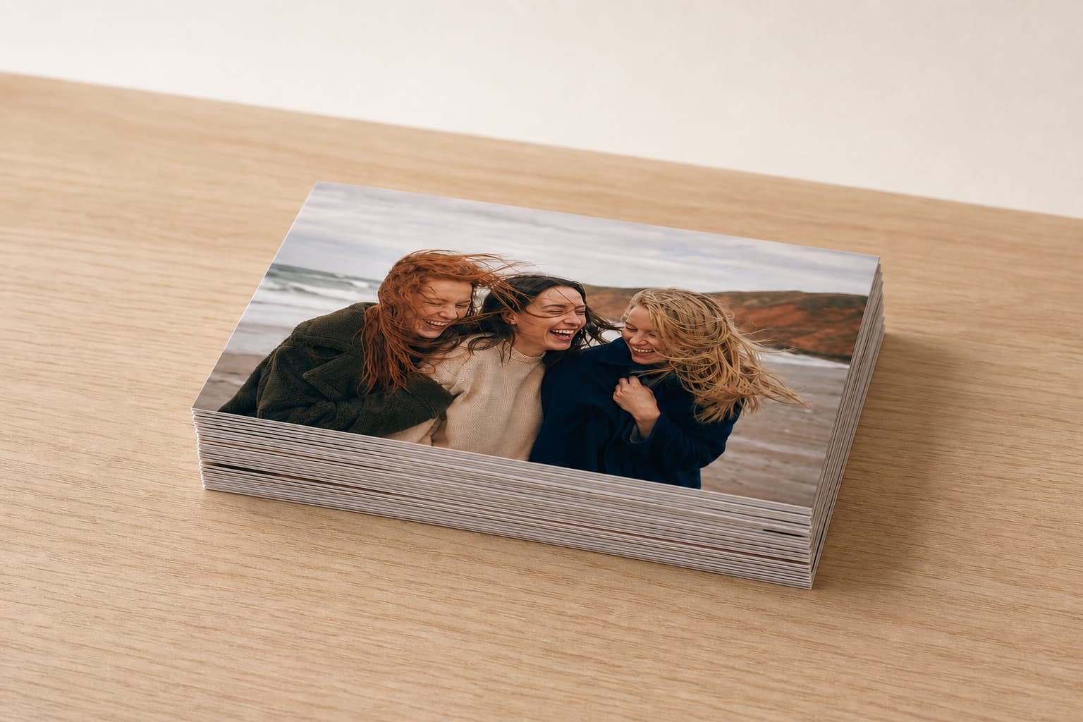 A shallow stack of 6x4" photo prints on a pale photo-lab worktable