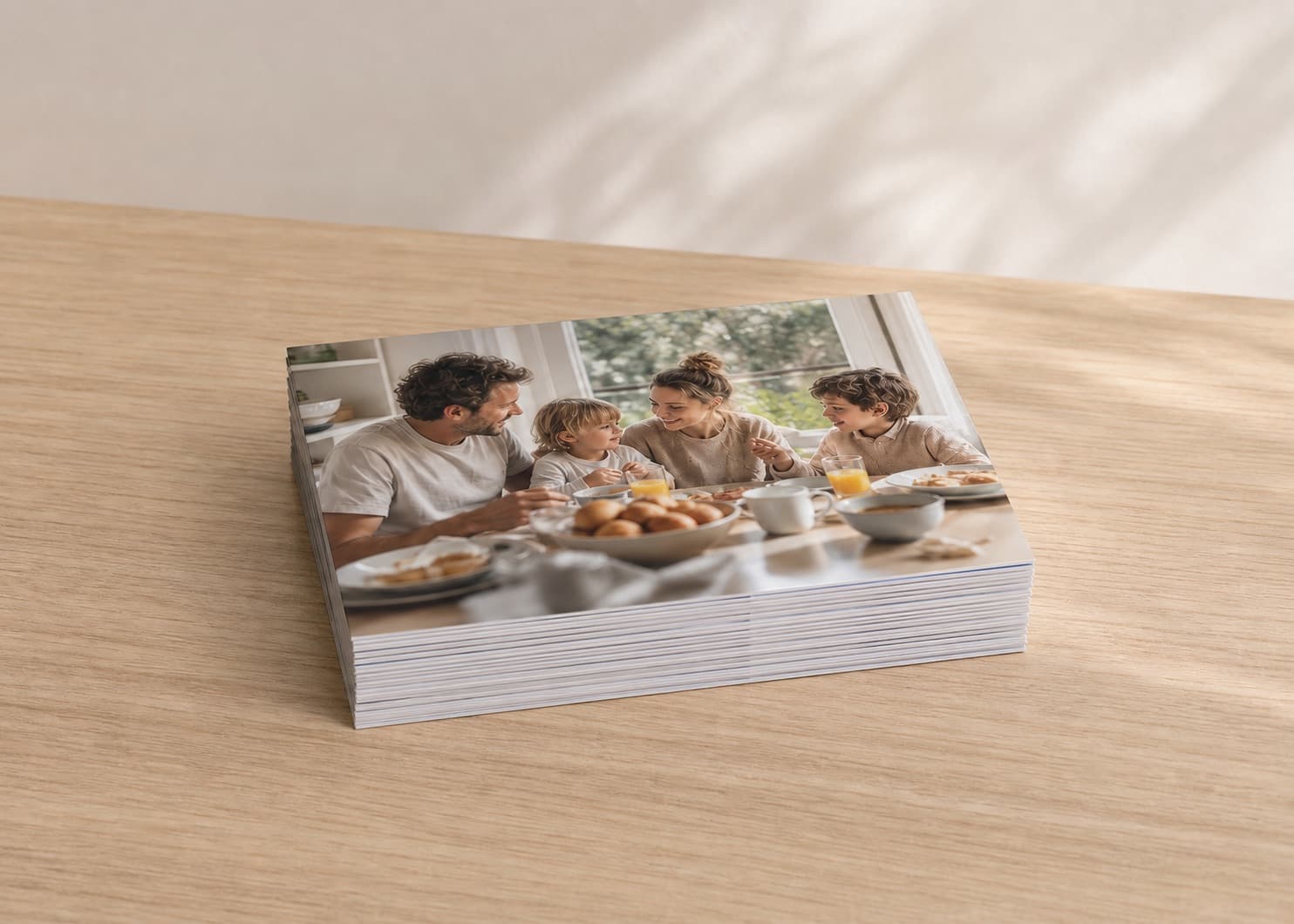 A shallow stack of 7x5" photo prints on a pale photo-lab worktable